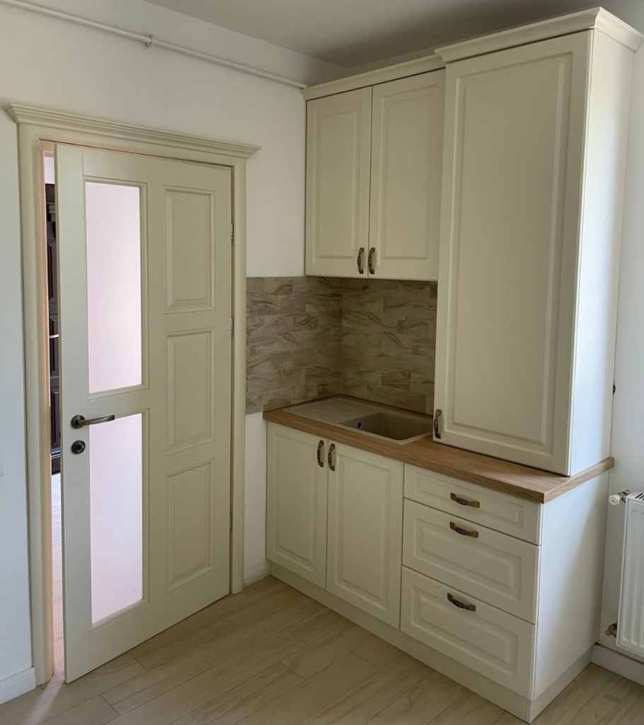 Bucătărie din mobilier clasic crem cu dulapuri din lemn masiv