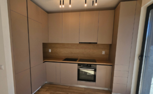 Bucătărie modernă din lemn masiv realizată la comandă, cu linii drepte și finisaje minimalist-elegante