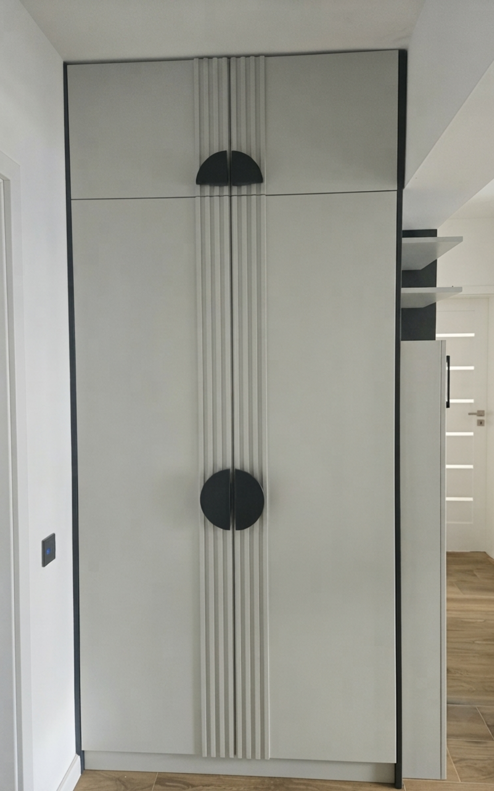 Șifonier minimalist gri cu riflaje decorative centrale și mânere semicirculare negre pentru uși din lemn masiv