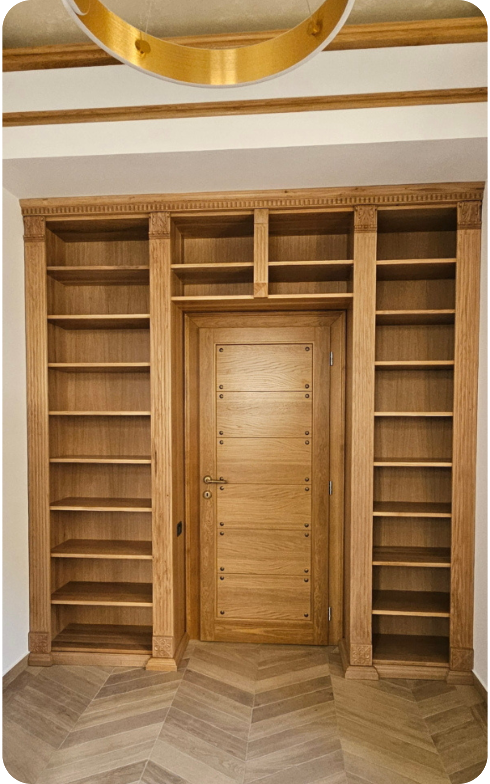 Bibliotecă din lemn de stejar integrată pe perete în jurul ușii de interior