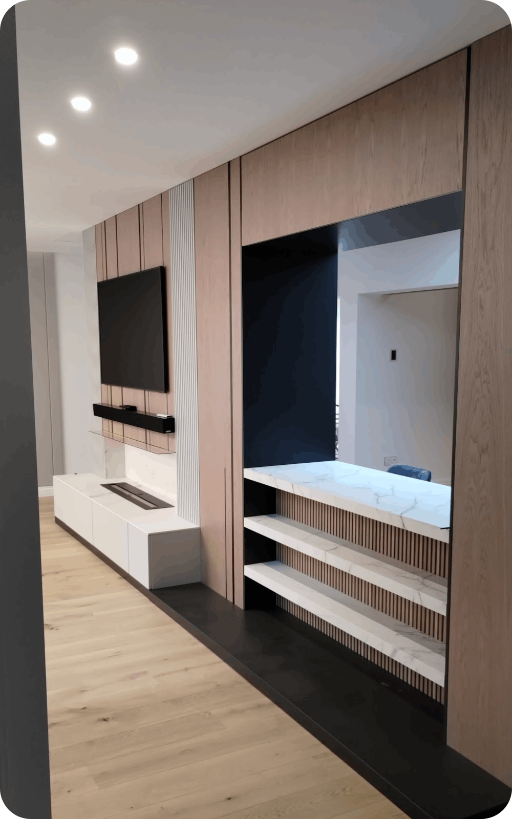 Ansamblu integrat de living cu comodă TV, riflaje din lemn și șemineu decorativ