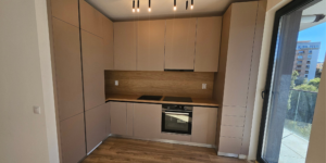 Bucătărie modernă din lemn masiv realizată la comandă, cu linii drepte și finisaje minimalist-elegante
