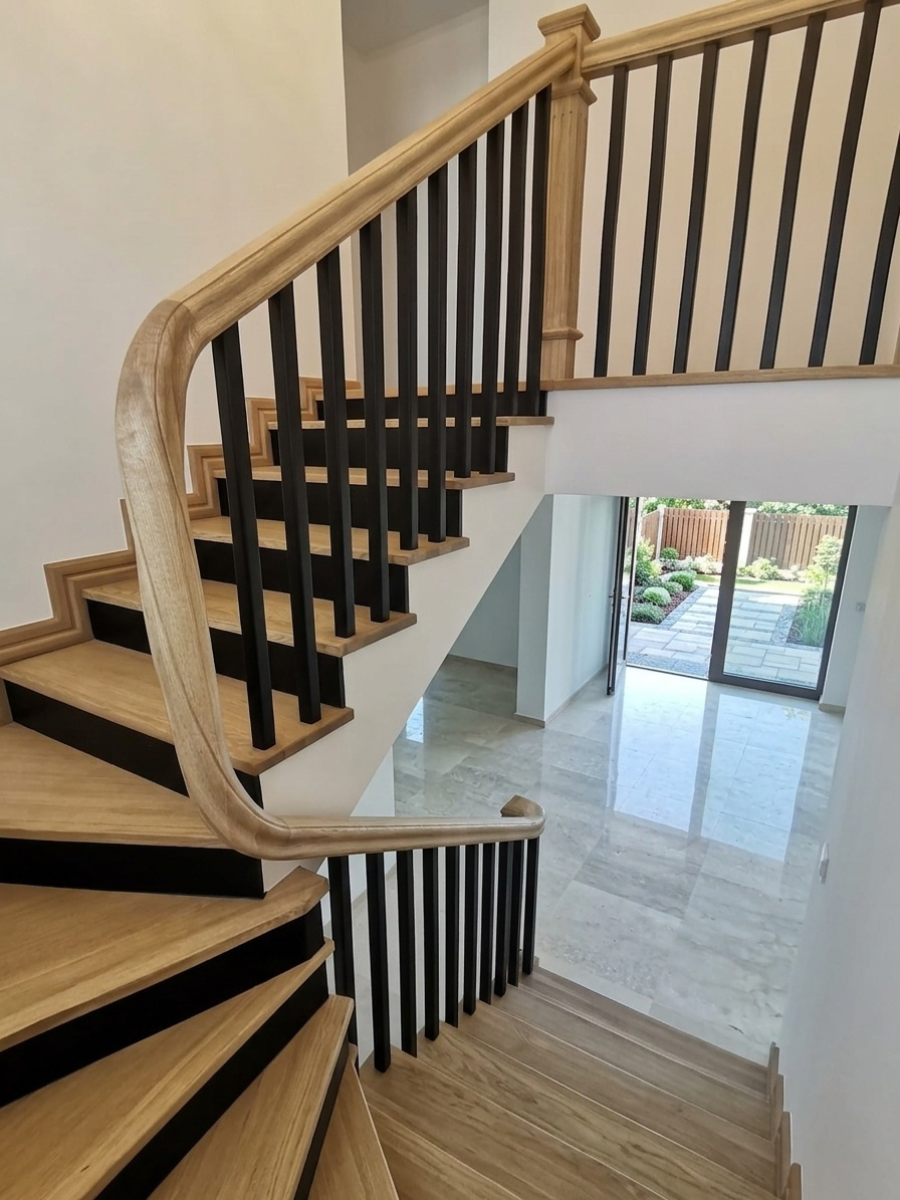 Scară balansată din lemn masiv cu contratrepte negre, balustradă din baluștri verticali și mână curentă curbată